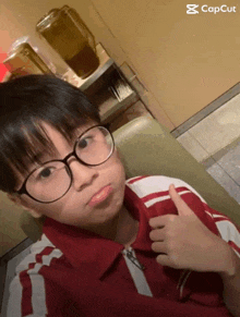 a young boy wearing glasses giving a thumbs up with the caption capcut