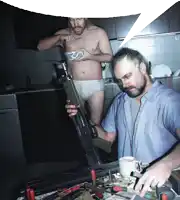 a man in underwear is holding a gun while another man looks on
