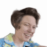 a woman wearing a blue and yellow shirt is smiling and laughing