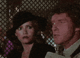 a man and a woman are standing next to each other with a blue light behind them .