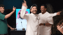 a man in a white shirt is laughing in front of a screen
