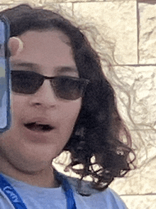 a girl wearing sunglasses and a lanyard that says gmy