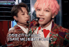a man with pink hair stands next to another man with a microphone