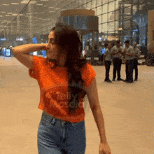 a woman wearing an orange t-shirt with telly masala on it