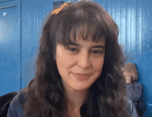 a woman with a yellow flower in her hair looks at the camera