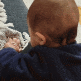 a baby is sitting on a couch and looking over his shoulder at something