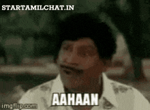 a man with a mustache is making a funny face with the words aahaan written on his face .