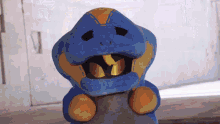 a blue and orange stuffed animal with a snake head