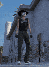 a person wearing a cowboy hat and a tank top that says anger