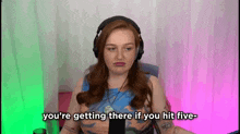 a woman wearing headphones says you 're getting there if you hit five .