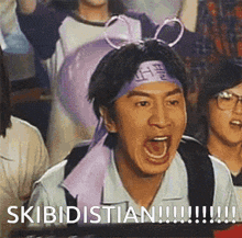 a man wearing a headband with bows on it is screaming in a crowd of people .