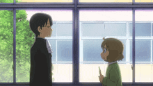 a man and a little girl are standing in front of a window