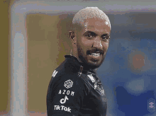 a man wearing a black shirt with azon and tik tok on the sleeve