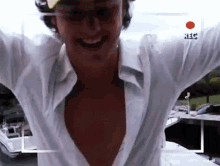 a man in a white shirt is smiling in front of a camera that says rec on it