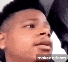 a close up of a young man 's face making a funny face on make a gif .