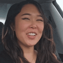 a close up of a woman 's face with a smile