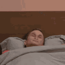 a man in a suit and tie is laying in a bed next to a can of soda .