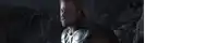 a man with long hair is holding a hammer in his hand in a dark room .