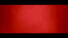 a red background with a black border and a blurred texture