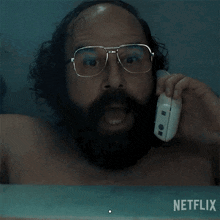 a man with glasses and a beard is talking on a cell phone with the words " smash it " written above him
