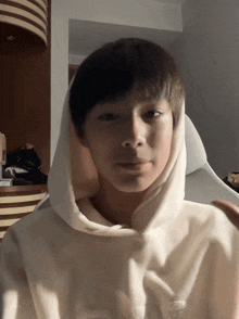 a person wearing a white hoodie with a hood
