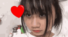 a girl with a red heart in her eye looks at the camera