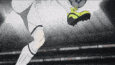 a soccer player kicking a ball with a yellow shoe on