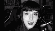 a woman wearing headphones and a microphone is smiling .