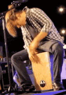 a man is playing a cajon on a stage