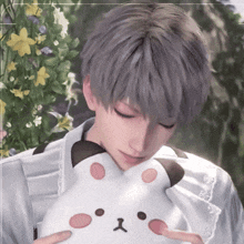 a man with gray hair is holding a stuffed animal