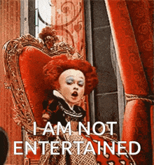 a woman in a red dress is sitting in a chair with the words " i am not entertained " written below her