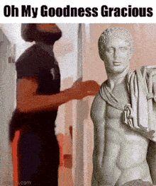 a man standing next to a statue that says oh my goodness gracious on it