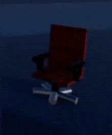 a red office chair is sitting in the dark in a room .