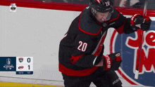 a hockey player with the number 20 on his jersey is holding a hockey stick