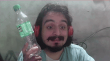 a man with a beard and headphones is holding a sprite bottle