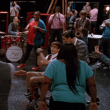 a man in a wheelchair is dancing in front of a drum set that says jazz ensemble