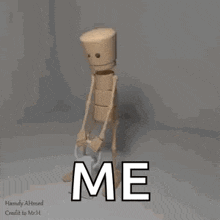 a 3d model of a wooden man with the words `` me '' written on it 's face .