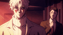 a man in a white sweater is standing next to another man in a brown suit