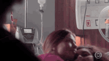 a woman is laying in a hospital bed with an iv in her hand