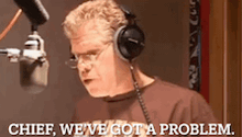 a man wearing headphones is talking into a microphone and says chief we 've got a problem .