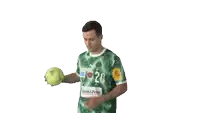 a man in a green shirt with the number 20 on it holds a tennis ball