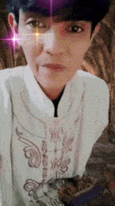 a man in a white shirt has a purple star in his eye