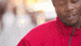 a man wearing a red jacket with the word north face on the collar