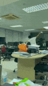 a man in a white shirt is standing in a messy office with his arms outstretched