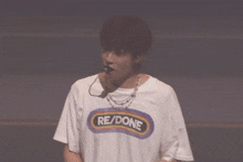 a man wearing a white shirt that says re/done