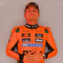 a man wearing an orange jacket with logos for dell technologies and monster energy