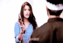 a woman is pointing a gun at a man and the word un-real is on the bottom