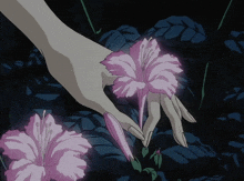 a woman 's hand is reaching out to touch a pink flower