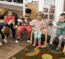 a group of children are playing with toys in a classroom with the letter t on the rug