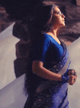 a woman wearing glasses and a blue saree has a heart on her head